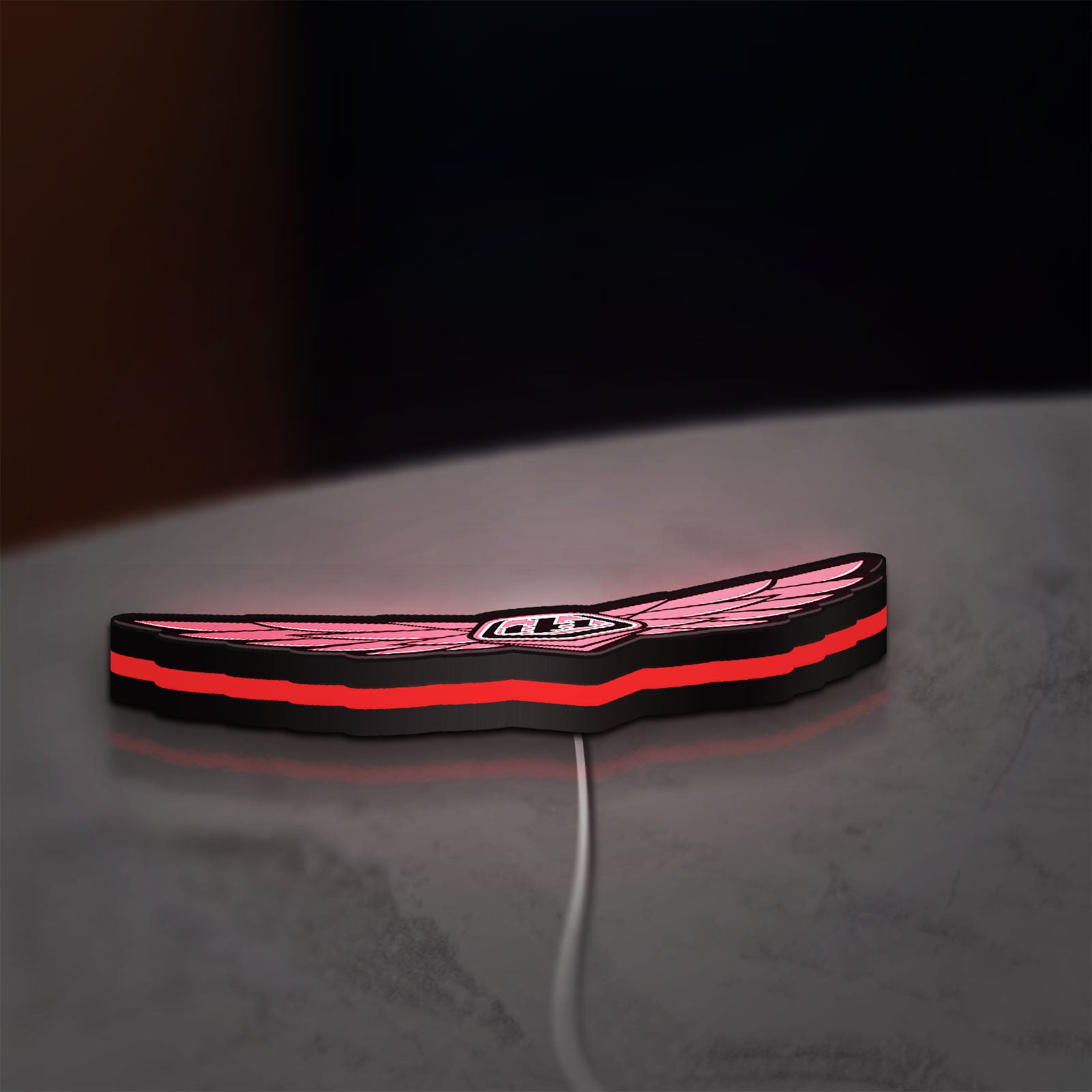 Troy Lee Designs LED lightbox lying flat on a desk with red glow