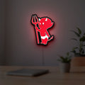Little Devil LED lightbox hanging on a room wall with soft red light