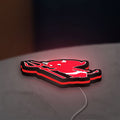 Little Devil LED lightbox lying flat on a desk with red glow