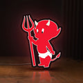 Front view of Little Devil LED lightbox sign glowing on a wooden desk
