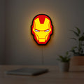 Iron Man LED lightbox hanging on a room wall with soft red light