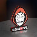 La Casa De Papel LED lightbox standing on a desk from an angled side view with red glow