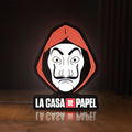 Front view of La Casa De Papel LED lightbox sign glowing on a wooden desk