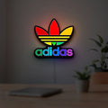 Adidas LED lightbox hanging on a room wall with soft white light