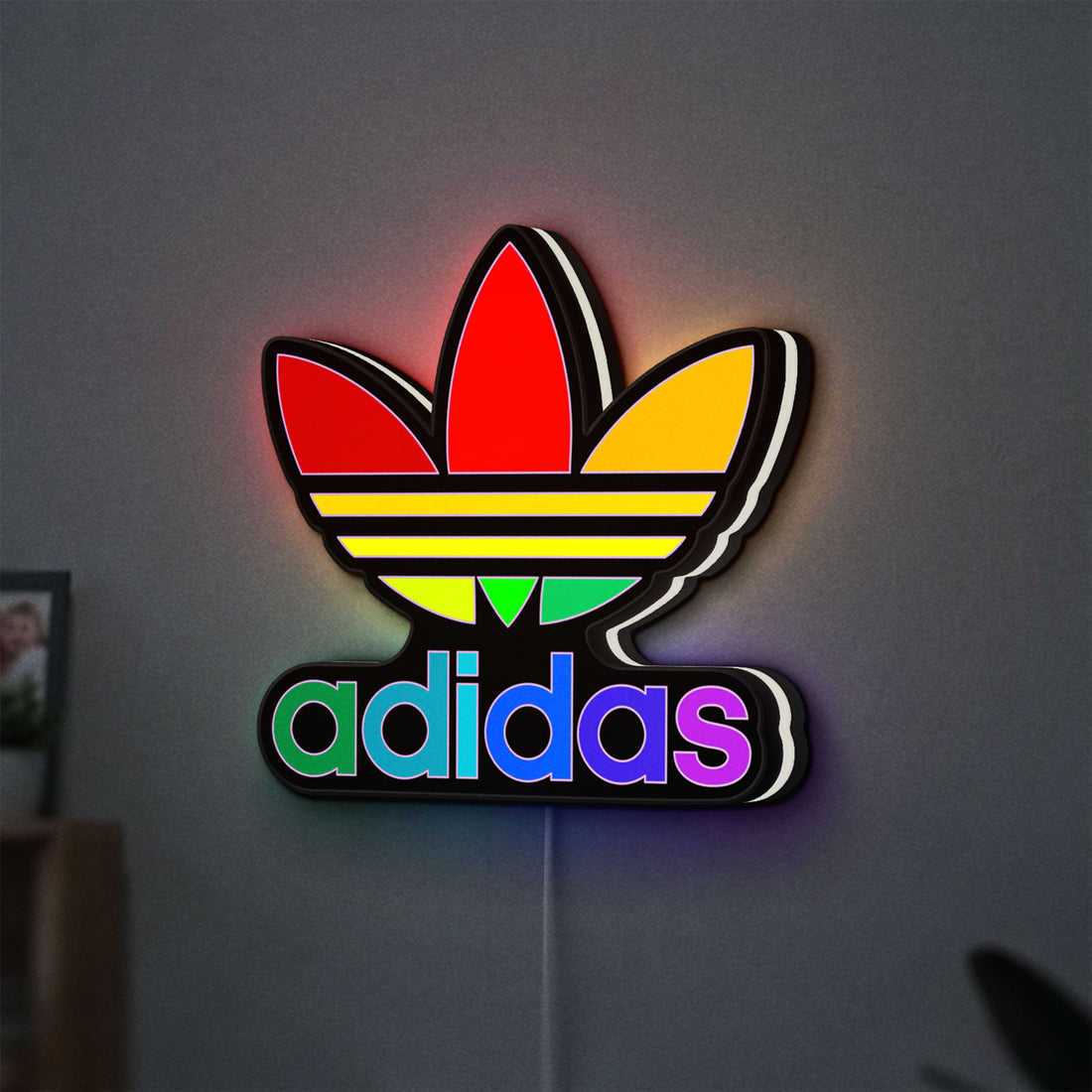 Adidas LED lightbox hanging on a wall with white glow
