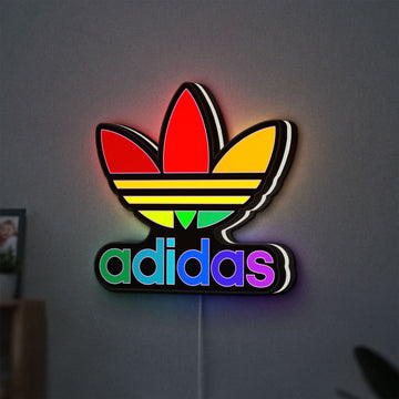 Adidas LED lightbox hanging on a wall with white glow
