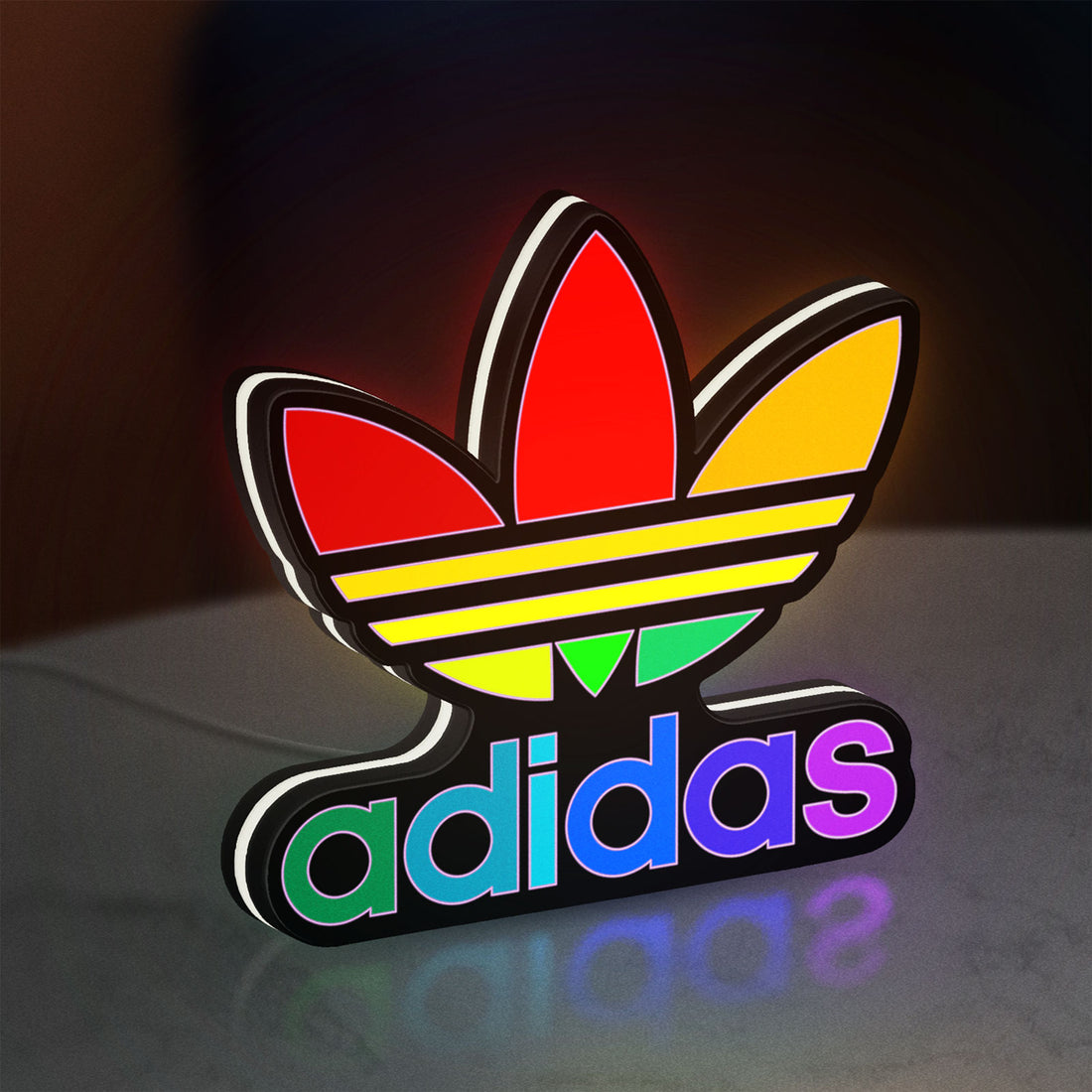 Adidas LED lightbox hanging on a wall with white glow