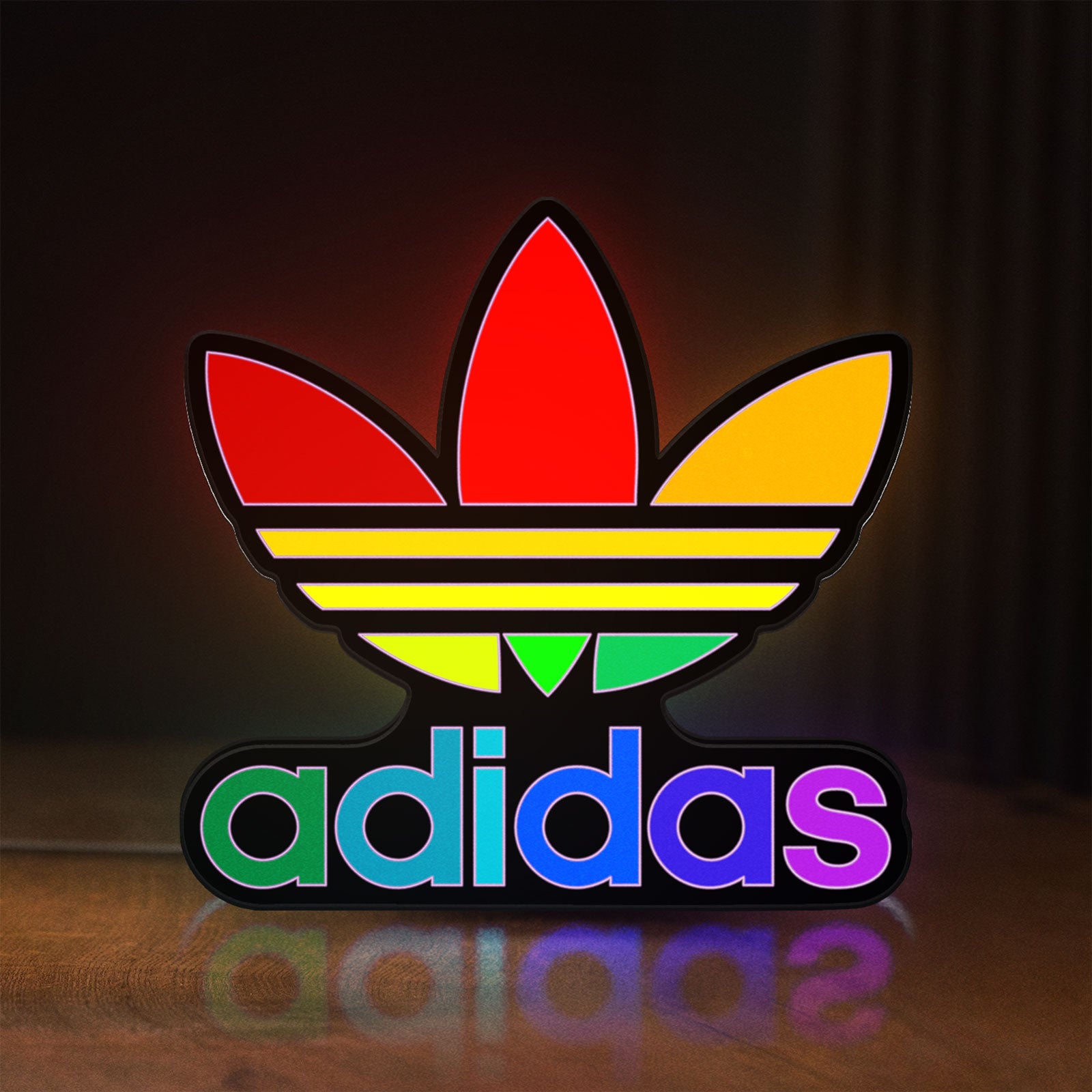 Front view of Adidas LED lightbox sign glowing on a wooden desk
