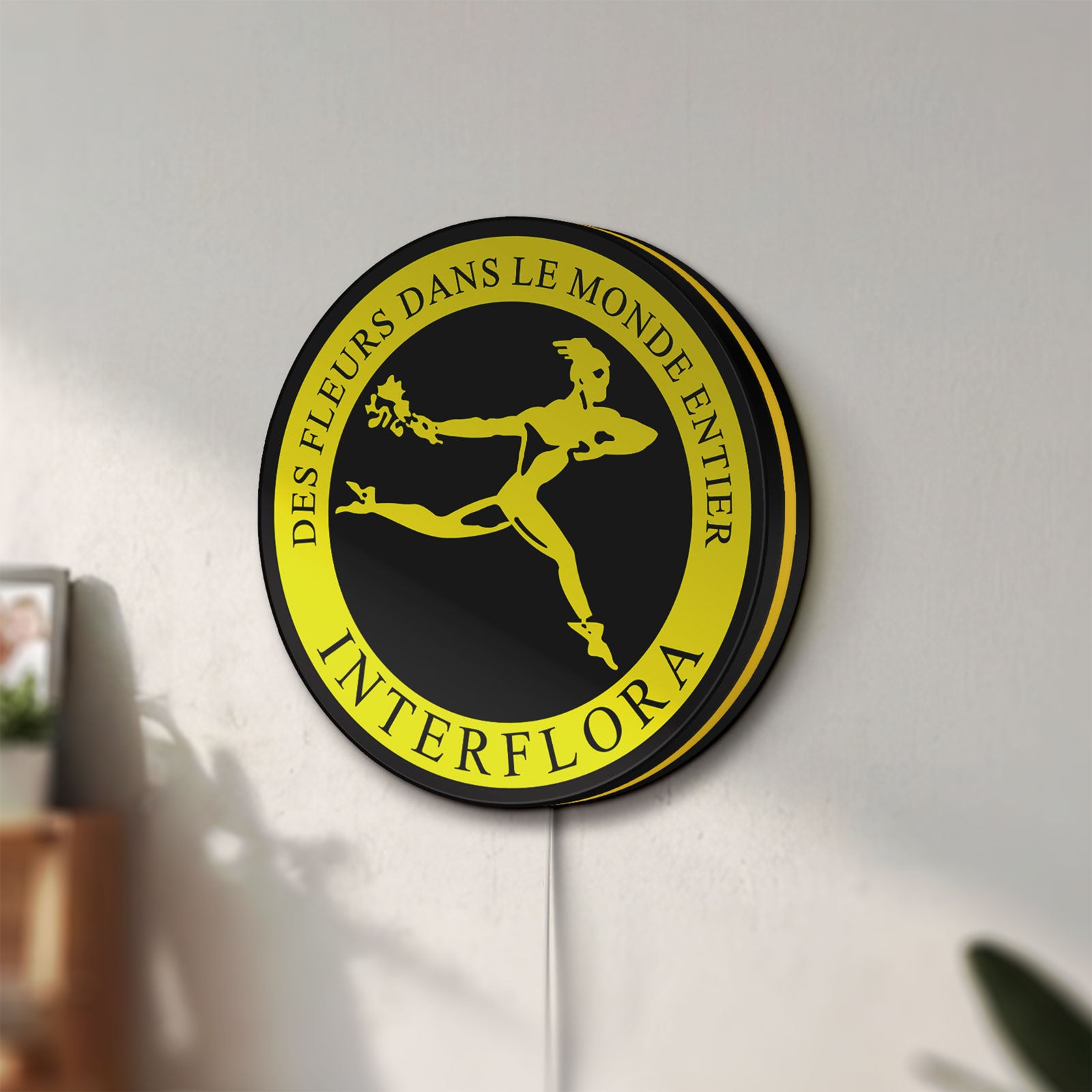Unlit Interflora Mercury Man LED lightbox mounted on a wall in daylight