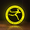 Front view of Interflora Mercury Man LED lightbox sign glowing on a wooden desk