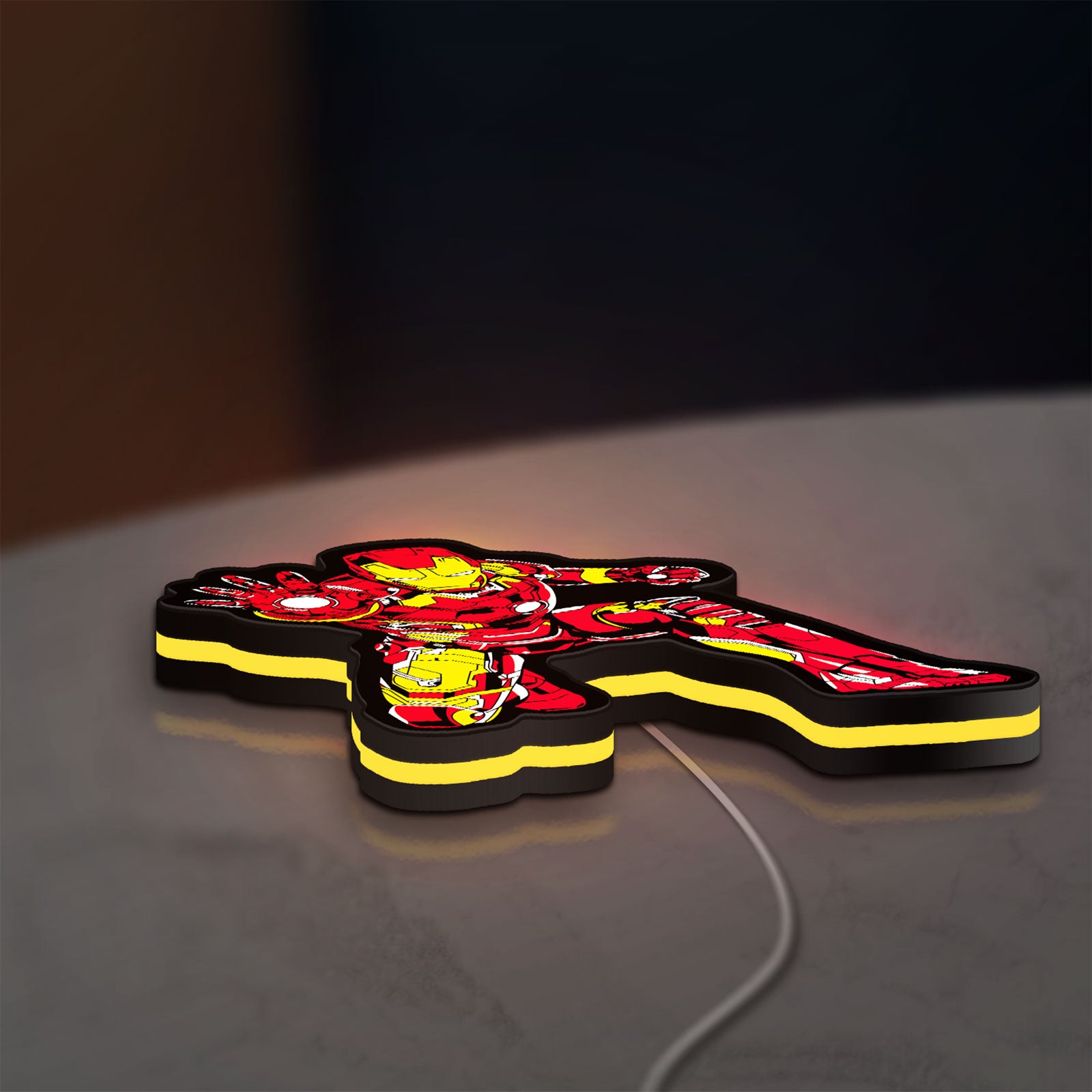 Iron Man LED lightbox lying flat on a desk with yellow glow