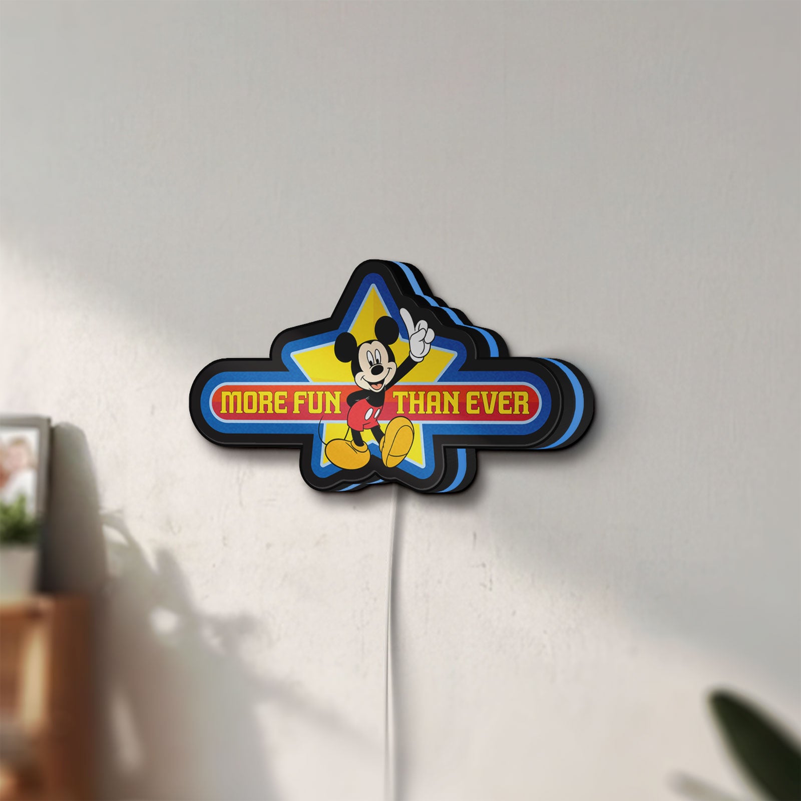 Unlit Mickey Mouse LED lightbox mounted on a wall in daylight