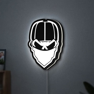 Skull Gang LED lightbox hanging on a wall with white glow