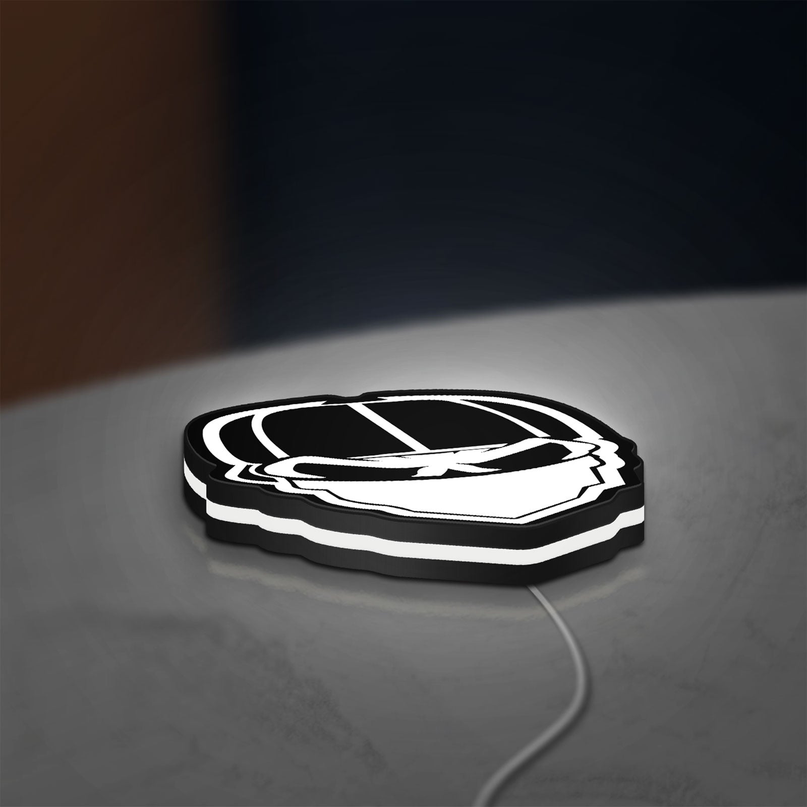 Skull Gang LED lightbox lying flat on a desk with white glow