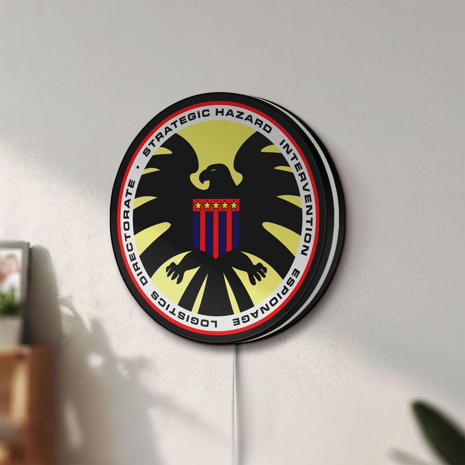 Unlit S.H.I.E.L.D. LED lightbox mounted on a wall in daylight