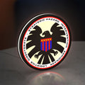 S.H.I.E.L.D. LED lightbox standing on a desk from an angled side view with white glow