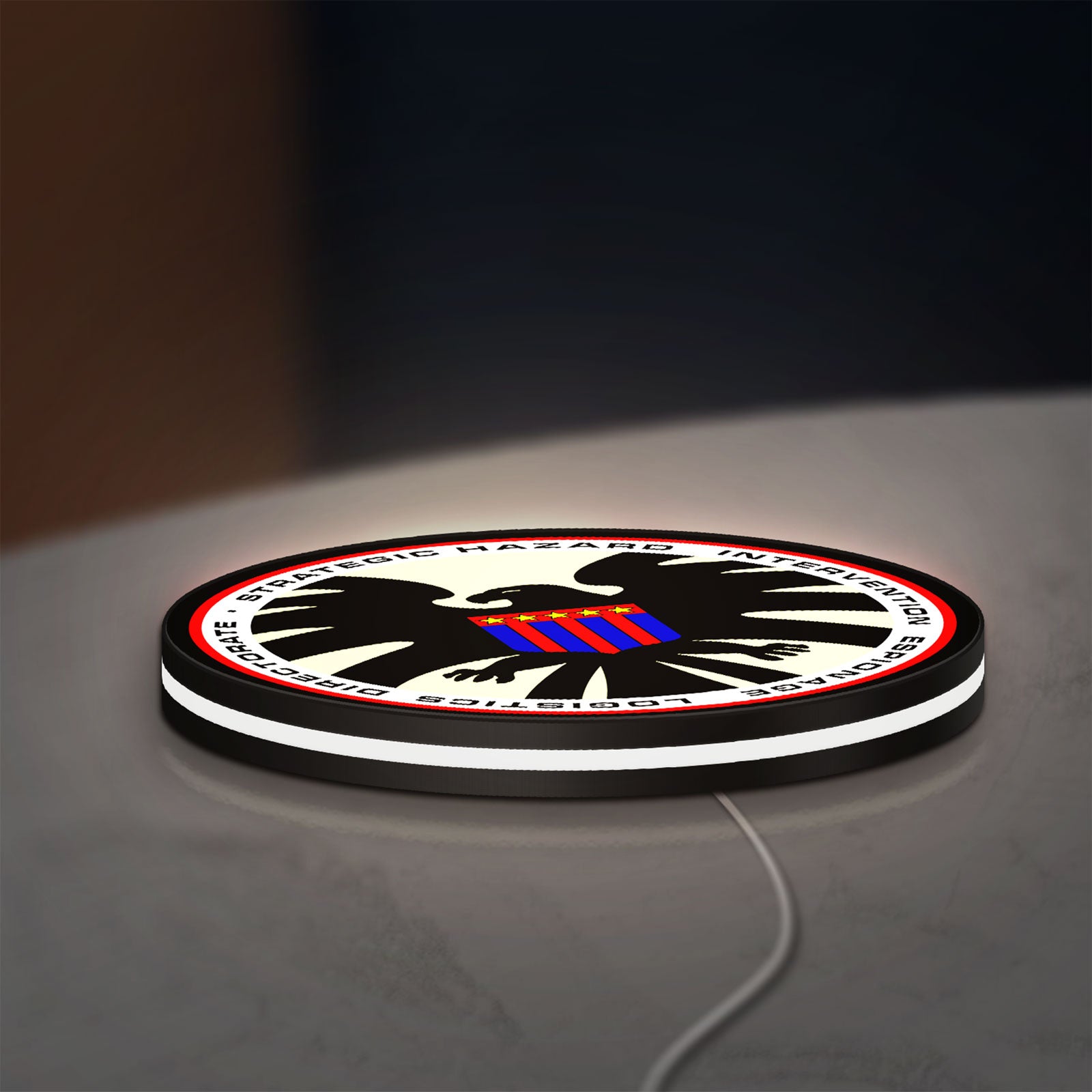 S.H.I.E.L.D. LED lightbox lying flat on a desk with white glow