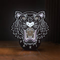 Front view of KENZO PARIS LED lightbox sign glowing on a wooden desk