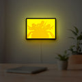 Charlie's Angels LED lightbox hanging on a room wall with soft yellow light
