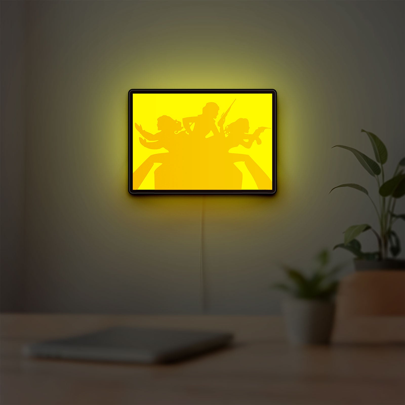 Charlie's Angels LED lightbox hanging on a room wall with soft yellow light