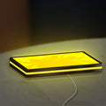 Charlie's Angels LED lightbox lying flat on a desk with yellow glow