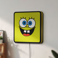 Unlit Spongebob Squarepants LED lightbox mounted on a wall in daylight