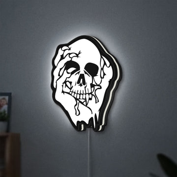 Skull LED lightbox hanging on a wall with white glow