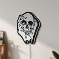 Unlit Skull LED lightbox mounted on a wall in daylight