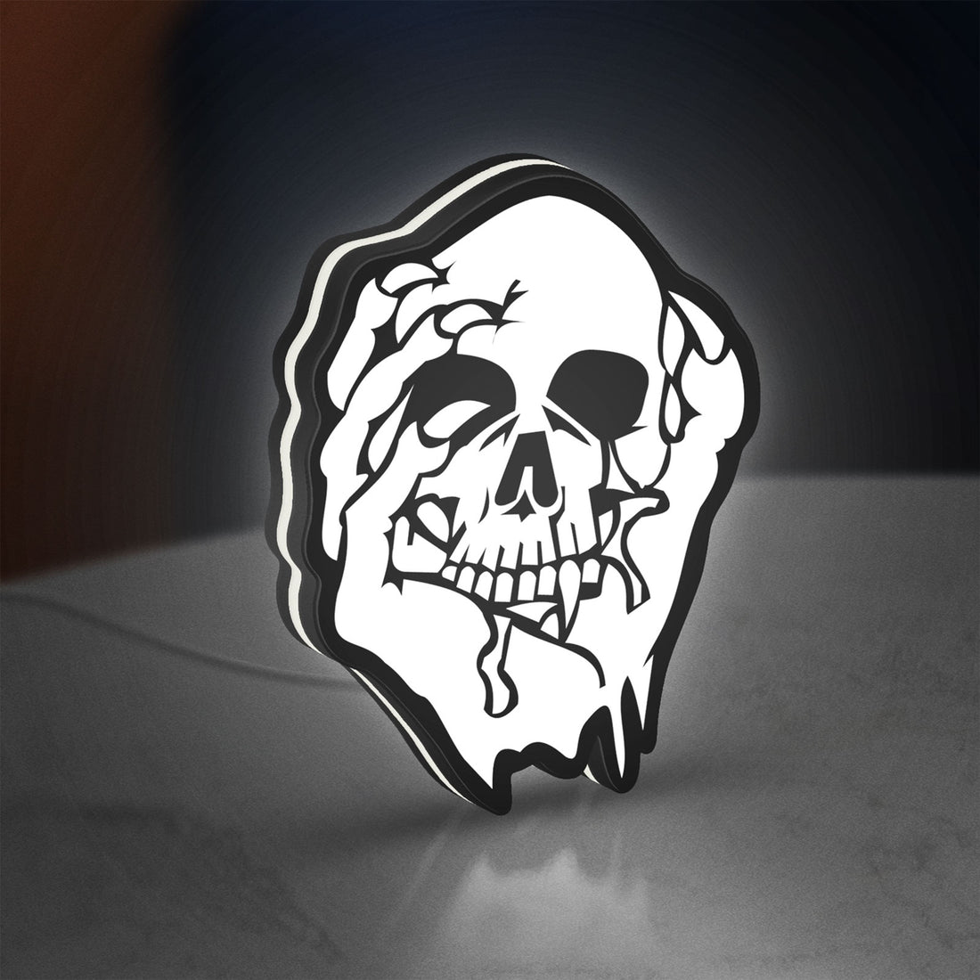 Skull LED lightbox hanging on a wall with white glow