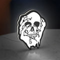 Skull LED lightbox standing on a desk from an angled side view with white glow