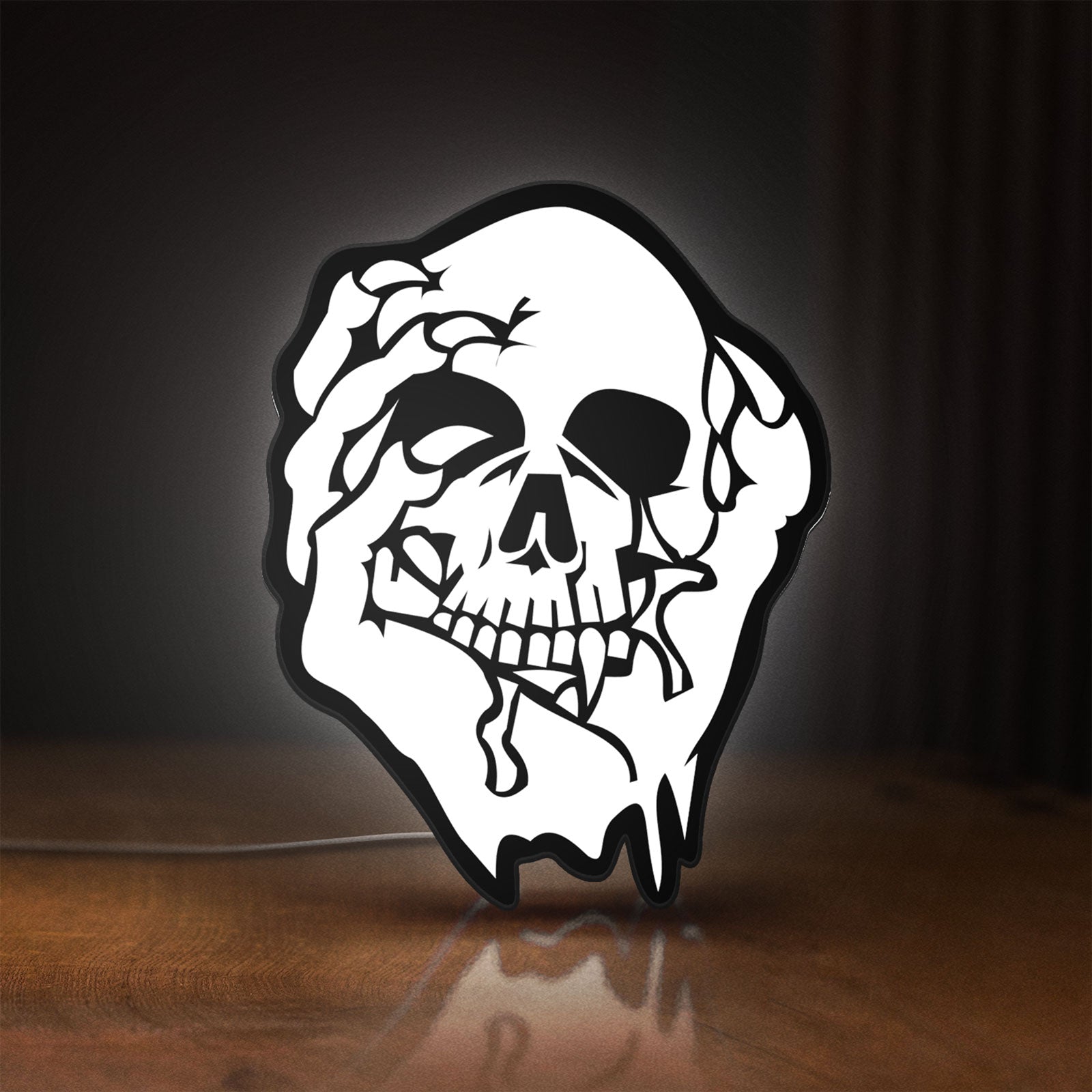 Front view of Skull LED lightbox sign glowing on a wooden desk