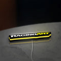 Racing Art LED lightbox lying flat on a desk with yellow glow