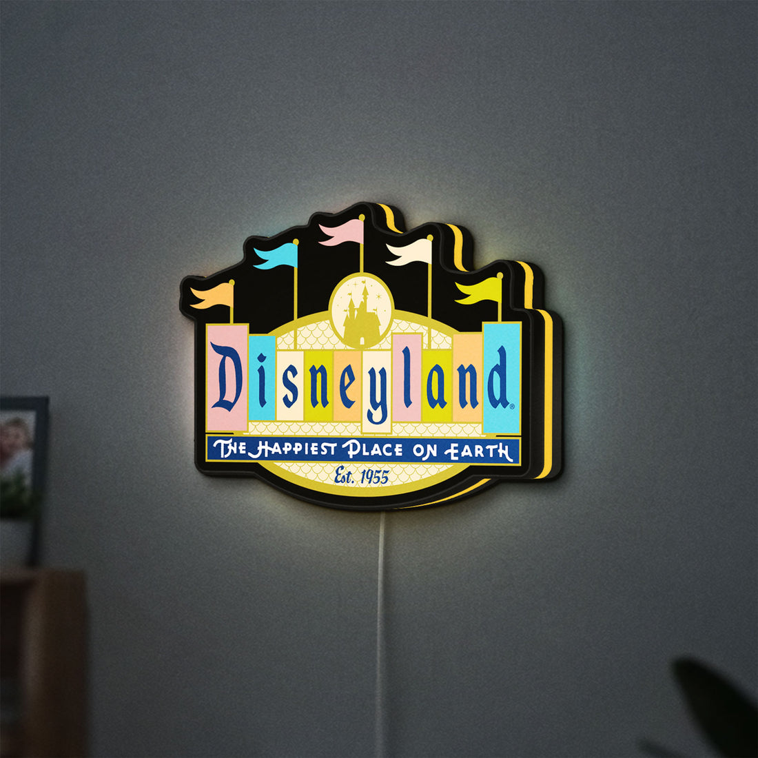 Disneyland Theme LED lightbox hanging on a wall with yellow glow