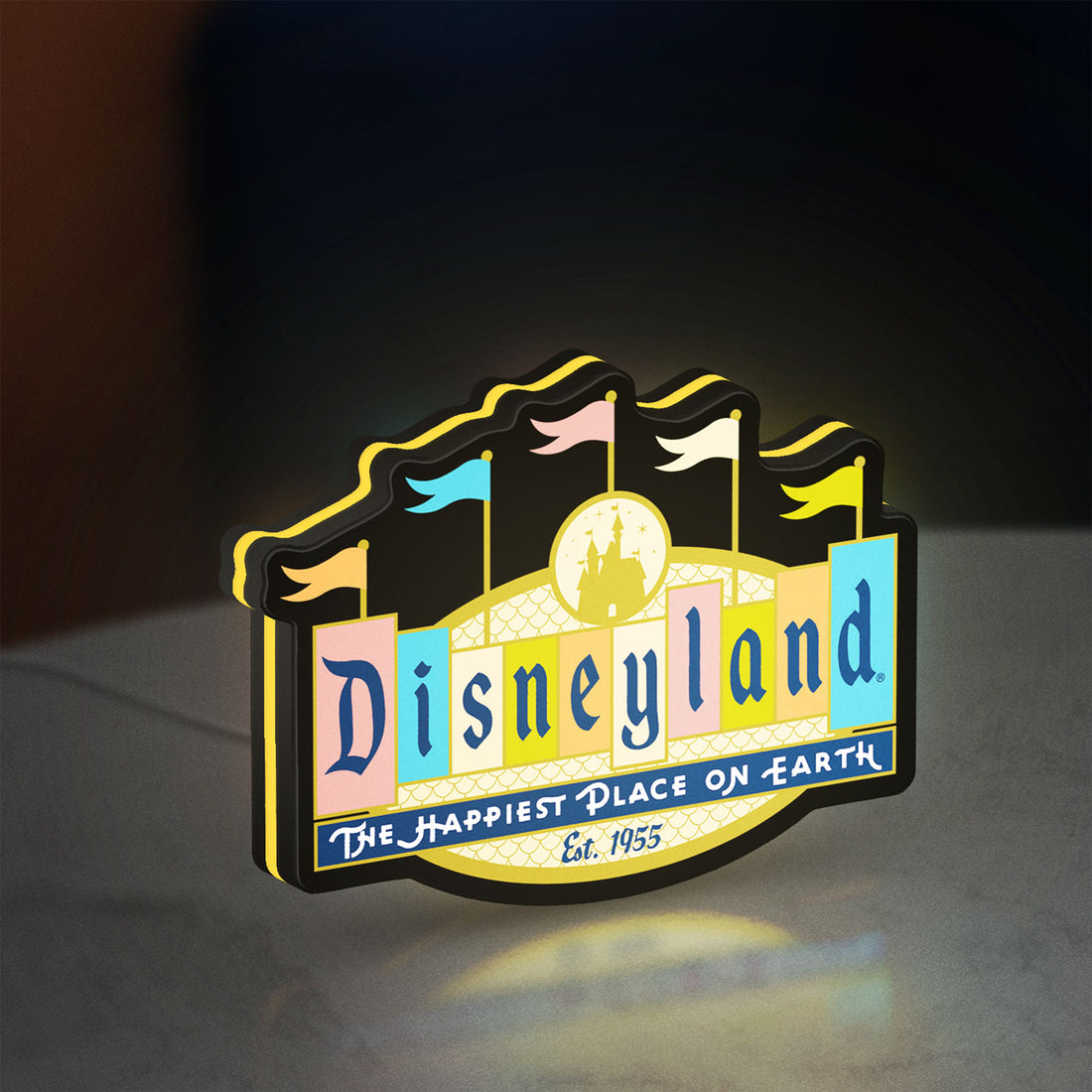Disneyland Theme LED lightbox hanging on a wall with yellow glow