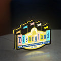 Disneyland Theme LED lightbox standing on a desk from an angled side view with yellow glow