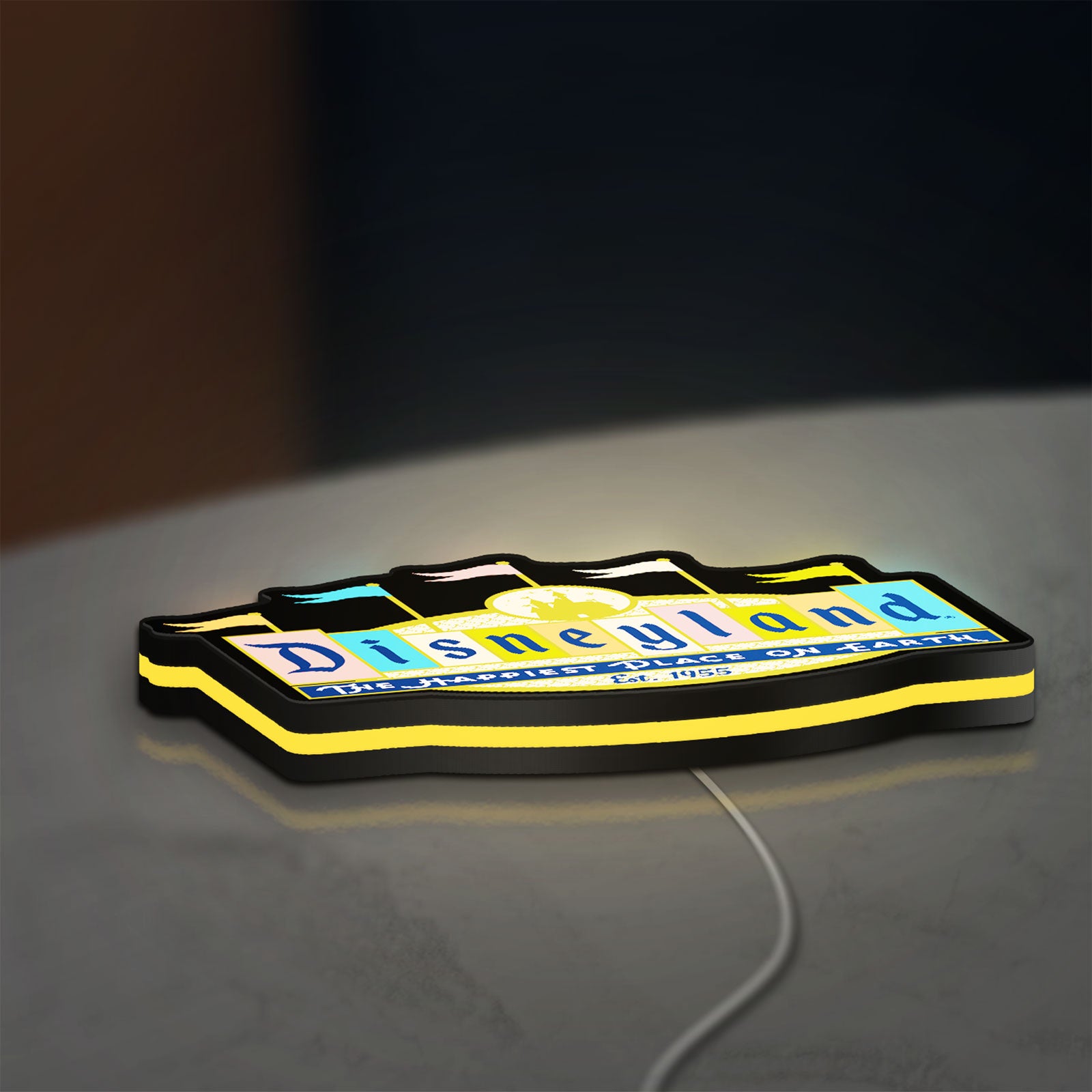 Disneyland Theme LED lightbox lying flat on a desk with yellow glow