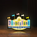 Front view of Disneyland Theme LED lightbox sign glowing on a wooden desk