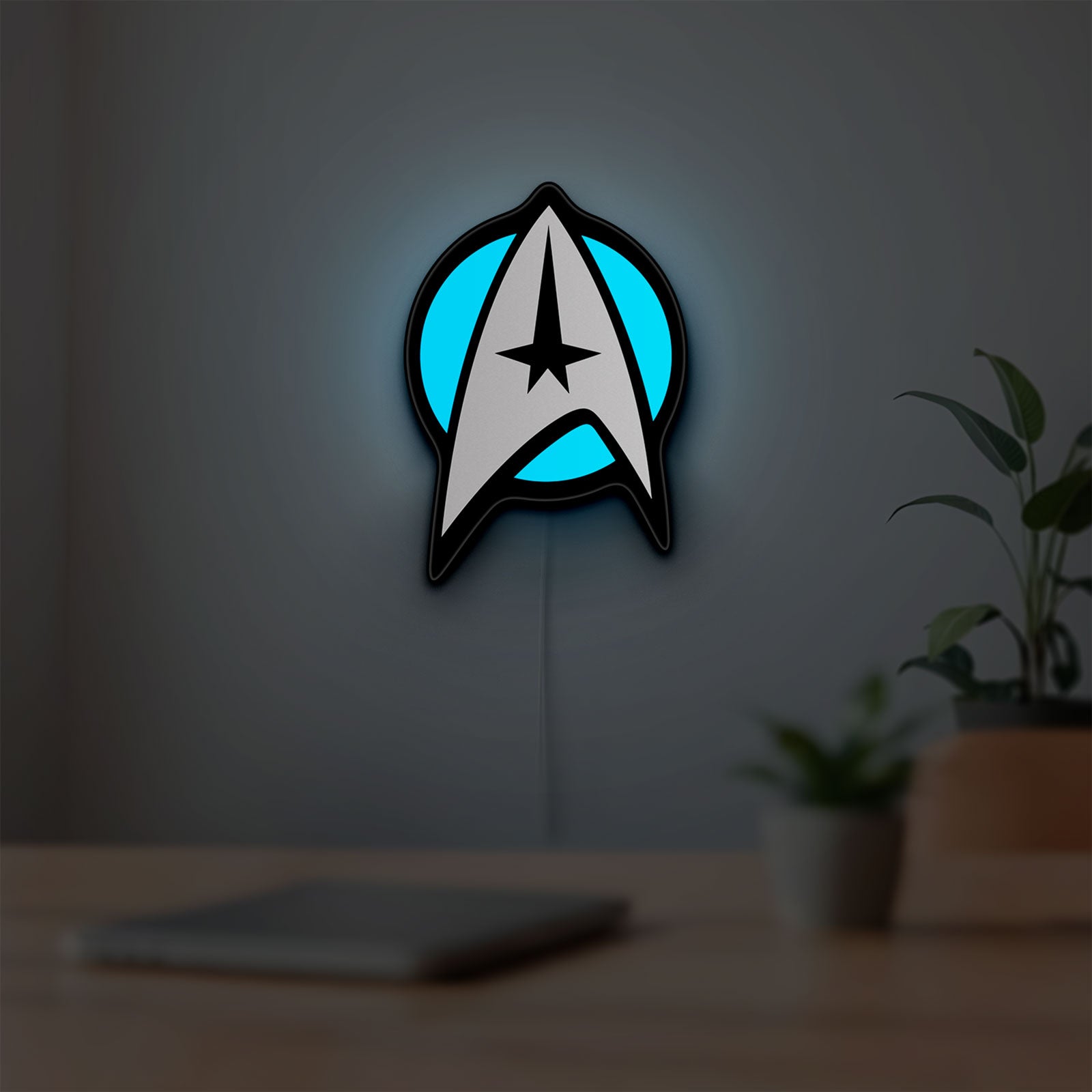 Star Trek Emblem LED lightbox hanging on a room wall with soft blue light