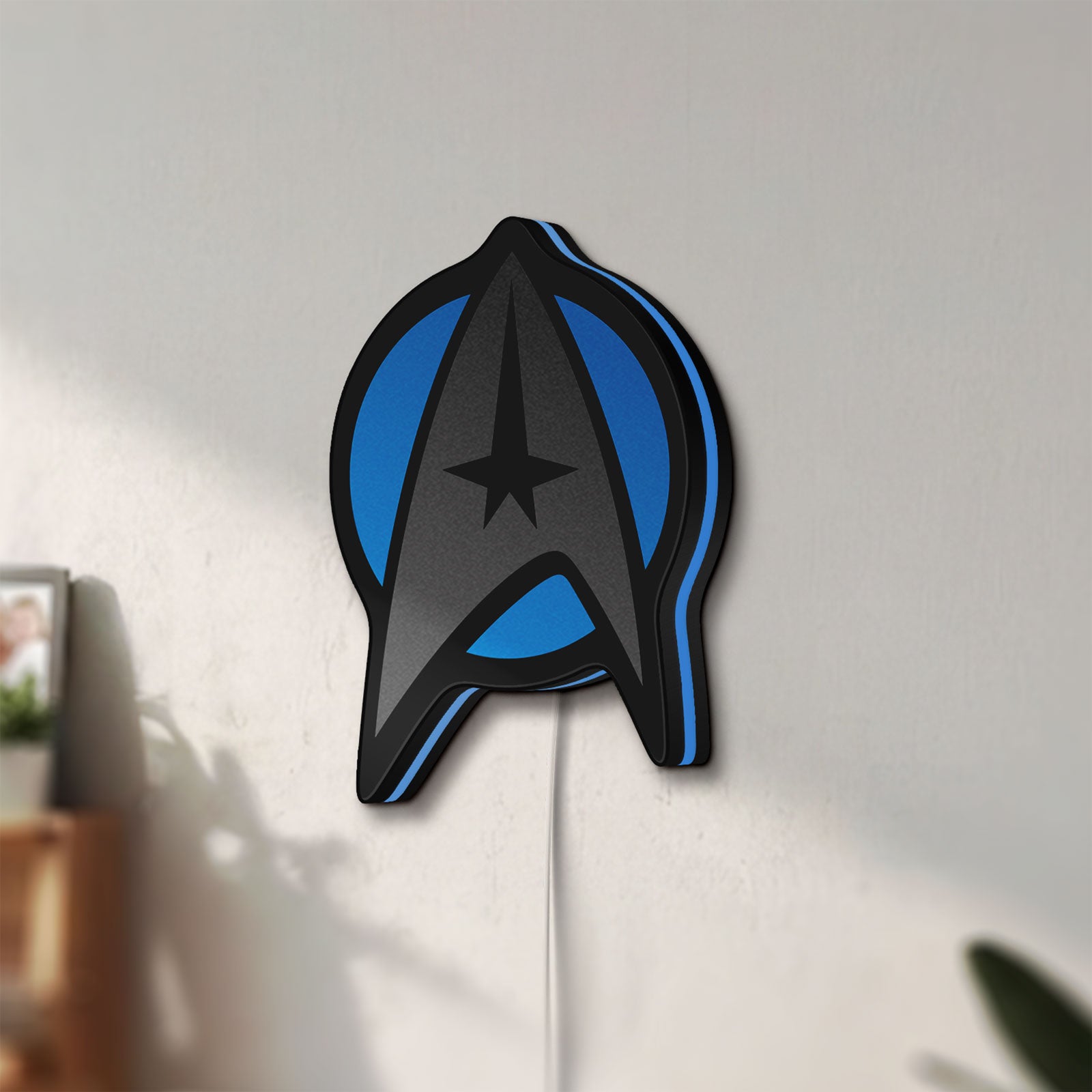 Unlit Star Trek Emblem LED lightbox mounted on a wall in daylight