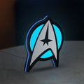 Star Trek Emblem LED lightbox standing on a desk from an angled side view with blue glow