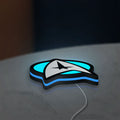 Star Trek Emblem LED lightbox lying flat on a desk with blue glow
