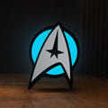 Front view of Star Trek Emblem LED lightbox sign glowing on a wooden desk
