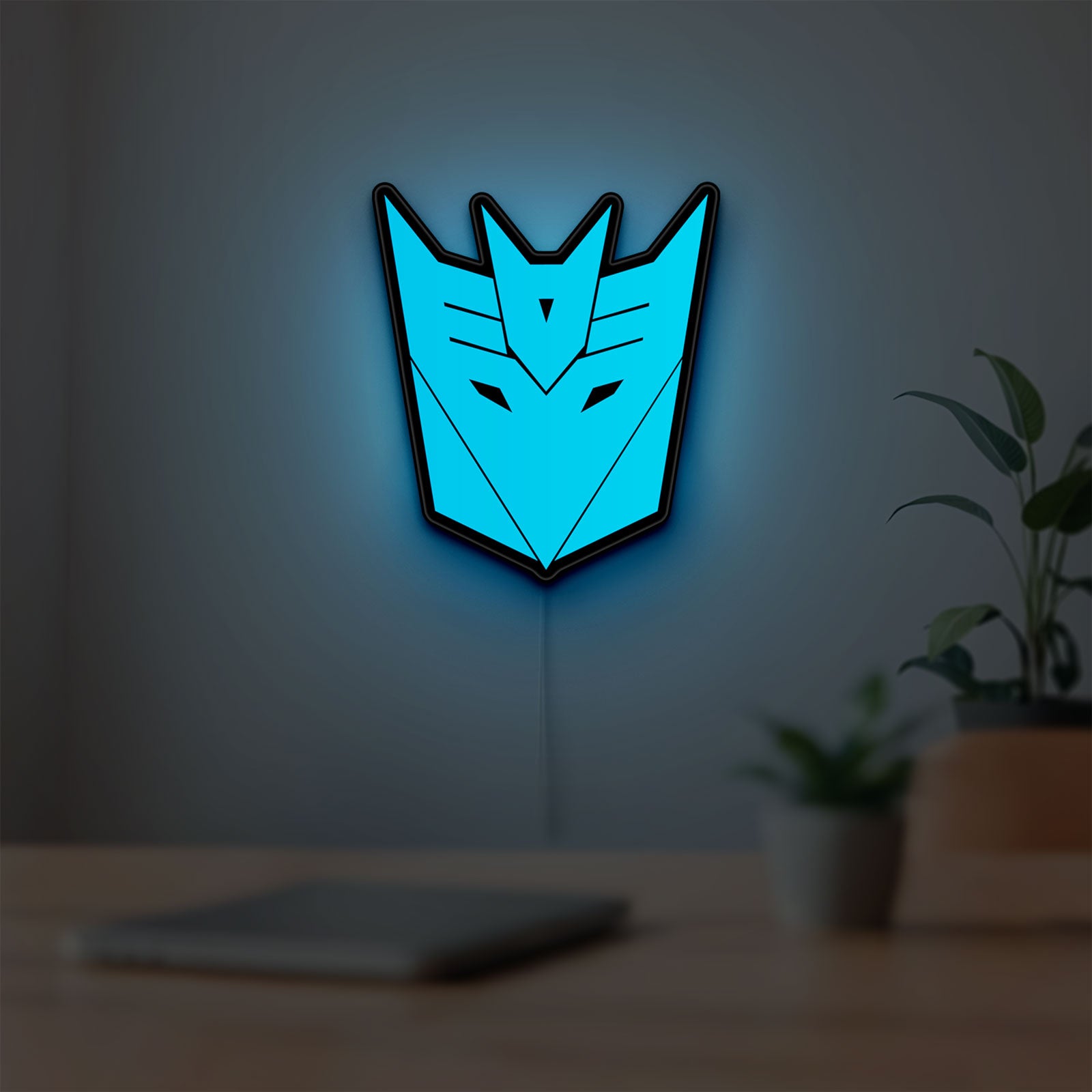 Decepticons LED lightbox hanging on a room wall with soft blue light