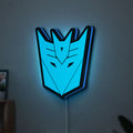 Decepticons LED lightbox hanging on a wall with blue glow