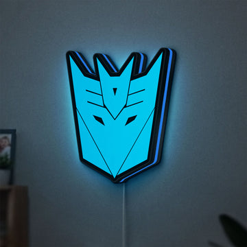 Decepticons LED lightbox hanging on a wall with blue glow