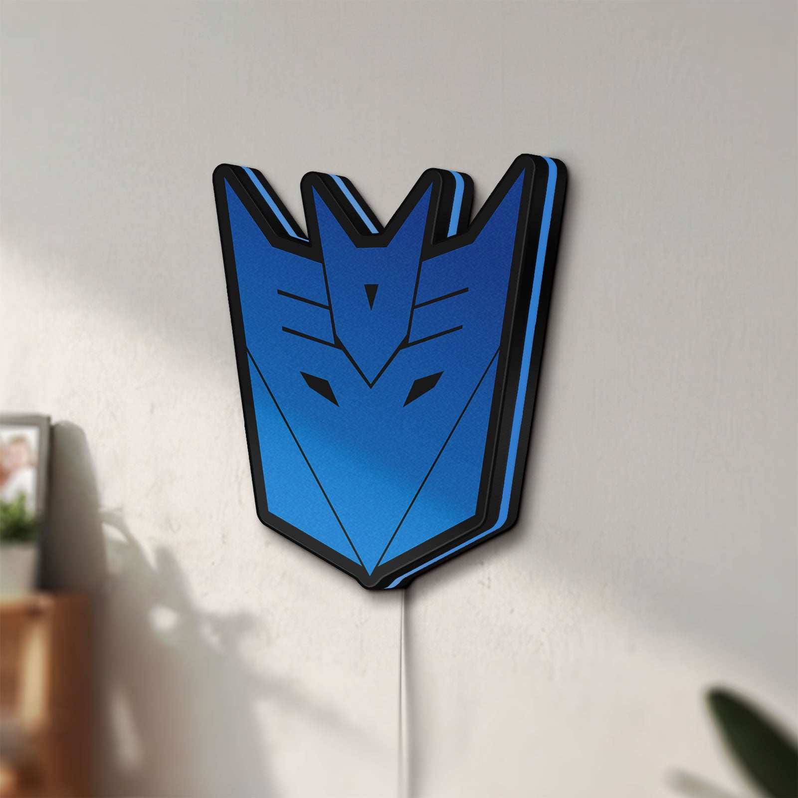 Unlit Decepticons LED lightbox mounted on a wall in daylight