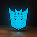 Front view of Decepticons LED lightbox sign glowing on a wooden desk