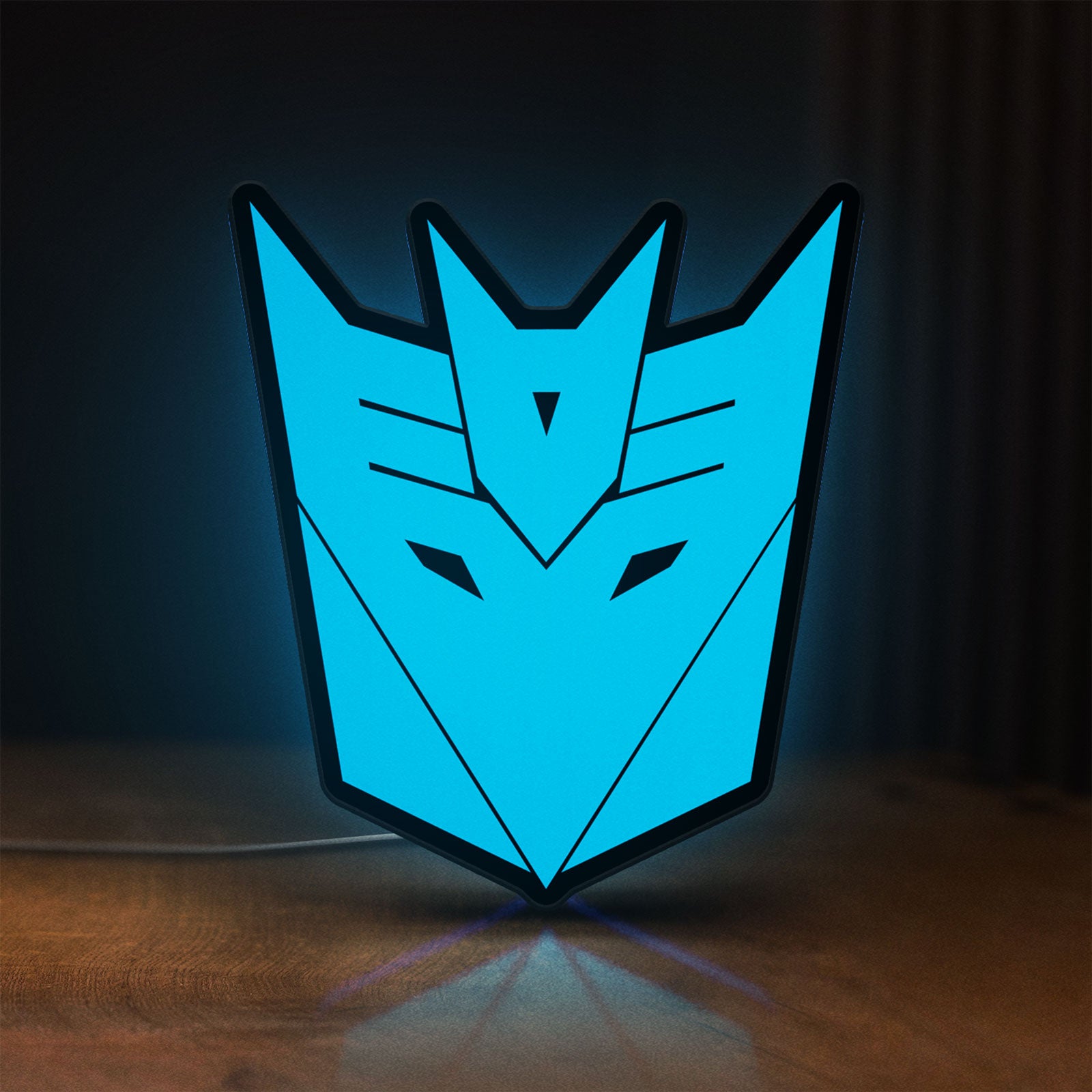 Front view of Decepticons LED lightbox sign glowing on a wooden desk