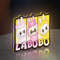 Labubu LED lightbox standing on a desk from an angled side view with yellow glow