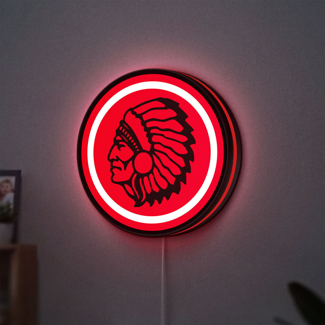 Apache Indian LED lightbox hanging on a wall with red glow